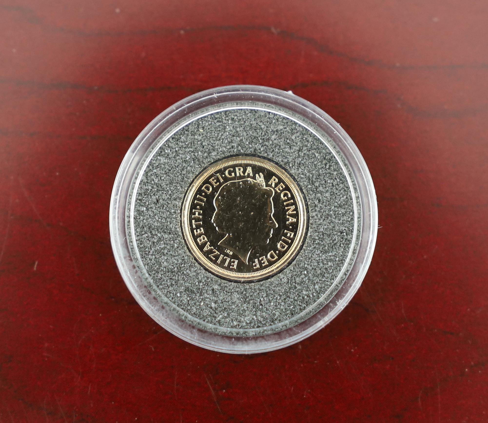 British Gold Coins, QEII 2000 1/4 sovereign of Britain and a 2008 25th anniversary 1/20th ounce gold angel coin, complete with certificates in a leather binder and a London mint office penny black 170th anniversary stamp